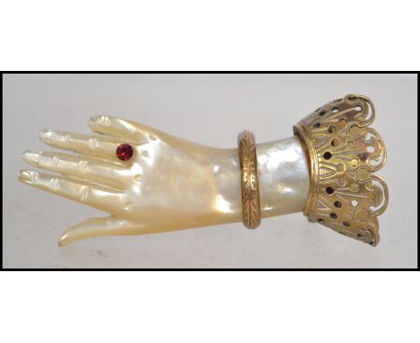 A 19th century Victorian mother of pearl hand brooch with ruby ' Ring ' decoration adorned with gilt metal fret pierced decor