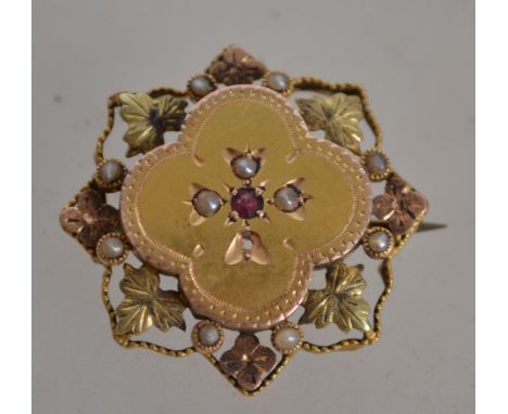 A Victorian 9ct gold ruby and dseed pearl ladies brooch of star form adorned with leaf borders Total weight 2.7g