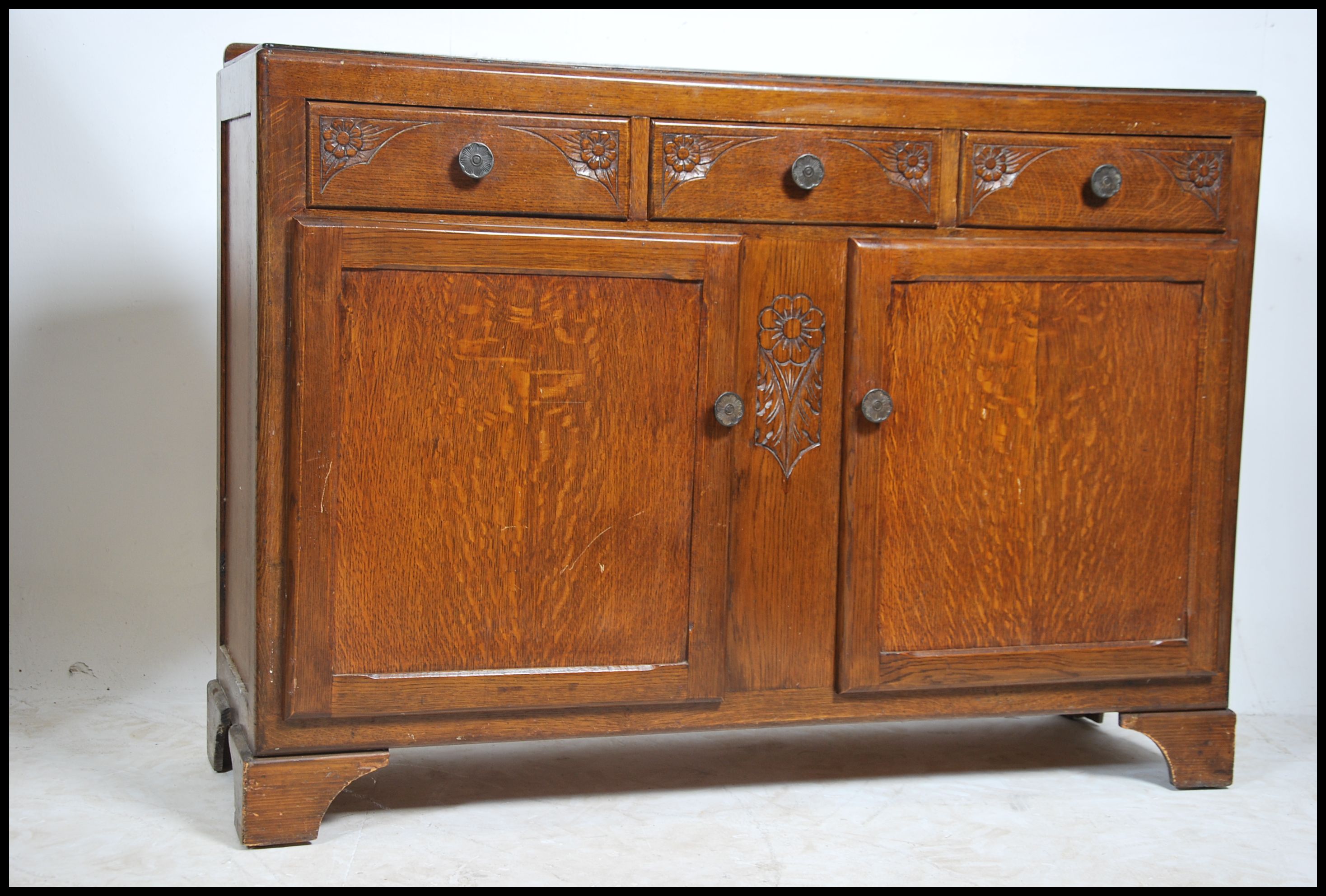 A 1930's Art Deco oak sideboard having embellished details to the front ...