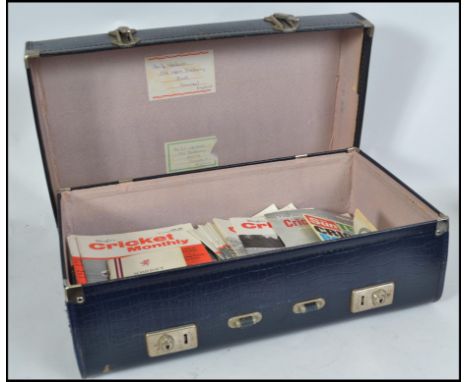 A collection of vintage 20th century Cricket Monthly magazines set within a blue faux crocodile skin suitcase