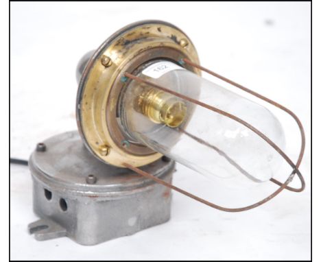 A 20th century Industrial cast metal heavy set bulkhead / dairy lamp with caged pendant style bulb on polished steel wall mou