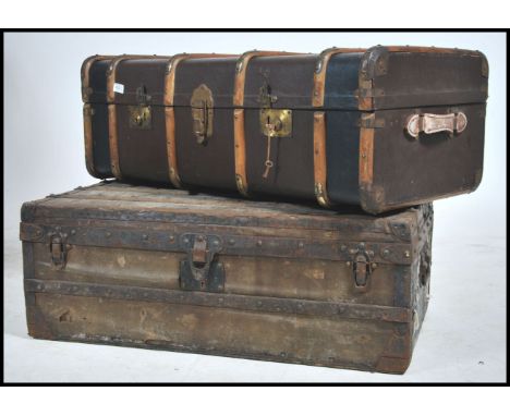 2 vintage steamer trunks from the early 20th century to include wooden bound canvas steamer trunk and a green canvas and meta
