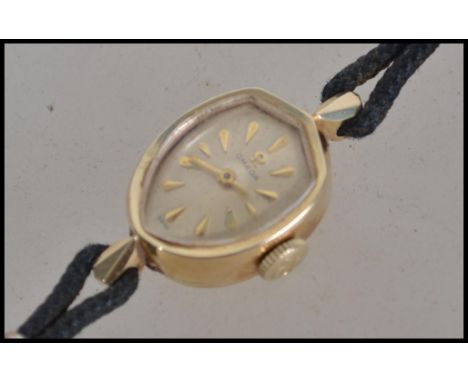 A ladies vintage 20th century Omega cocktail watch with an armorial shield shape dial with batons on a diapered ground, withi