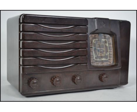 An vintage early to mid 20th century Bakelite valve radio by Westminster. Dials, knobs and speaker to the front. 