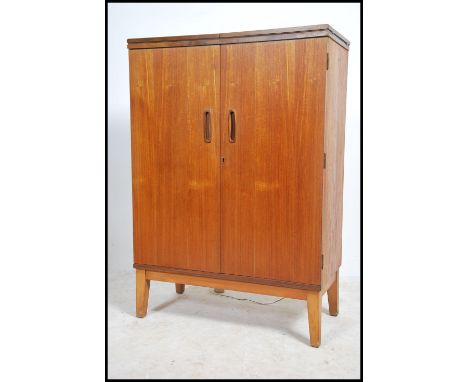 A 1970's rare believed G-Plan cocktail - drinks cabinet being raised on square tapered legs with full length doors having app