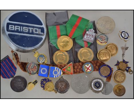 A collection of vintage medals and enamel badges etc to include a Bristol car badge, military enamel badges, sports badges, s