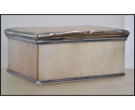 An 18th century mother of pearl rectangular snuff box, hinged  cover, engraved silver scrolling mounts. Measures 8cm wide. 