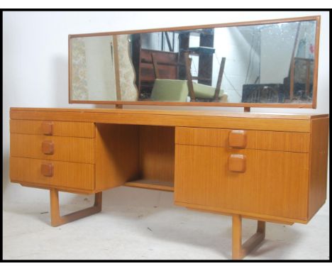 A vintage retro 20th century teak wood dressing table. Full length mirror above a series of drawers and cupboards raised on s