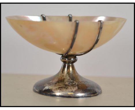 A silver hallmarked mother of pearl salt. A mother of pearl bowl raised on a pedestal silver base. Makers marks for Arthur Jo