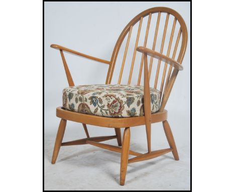 A retro original vintage Ercol light blond wood windsor pattern armchair  / lounge chair being raised on turned legs with sha