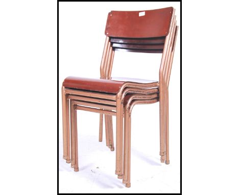 A stack of 4 vintage mid century Industrial stacking chairs having enamel painted tubular metal frames with ply panel seats a