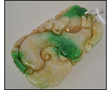 A Chinese jade carved pendant in the form of dragons / dogs of fu having a silver bale clasp atop. Size 6cms / 54.3g