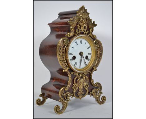  A 19th century French bracket clock having gilt ormulu embellished shaped case and raised on scrolled rococo feet. Enamel di
