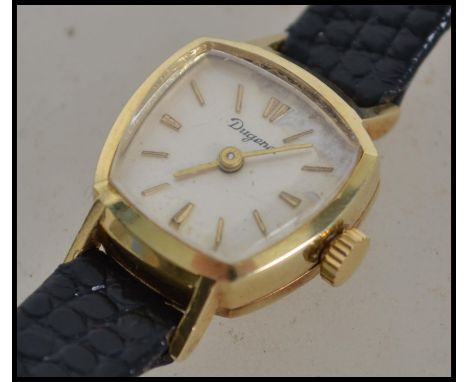 A vintage 14 carat gold ladies watch by Dugena.  This German watch is stamped 0'585, has a cream enamel dial with gilt batons