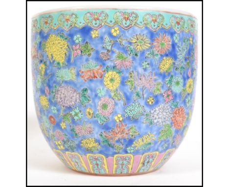 A Chinese famille rose cylinder shaped planter having a pastel blue ground with foliate decoration and geometric borders. Mea