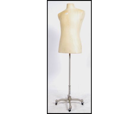 A vintage dressmakers dummy /  mannequin raised on a stunning industrial metal tubular stand on castors. 