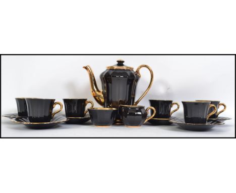 A vintage boxed 20th century coffee service by Wade, looks to be unused in the original box, black finish with gilt detail to