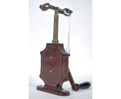 A 19th century German patented manual centrifuge test tube instrument with cast metal body in burgandy with gilt coachlining 