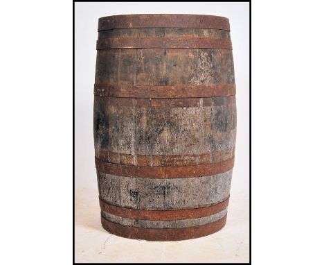 A full sized vintage 20th century oak coopered barrel having cast iron banding. Remains of paintwork to the top ( see illustr