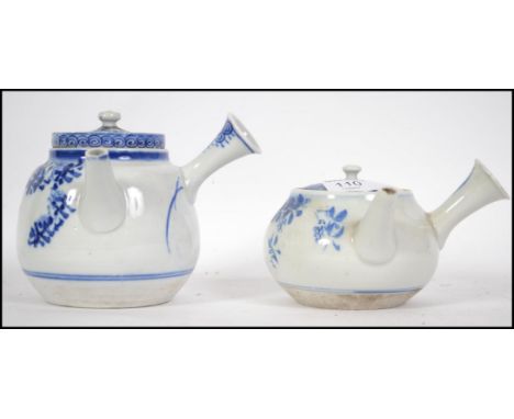 Two early 20th century Chinese blue and white ceramic teapots. Each with side handles and decorated with sweeping design. The