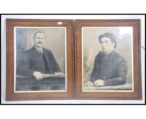 A large pair of vintage early 20th century black and white photographic portrait studies of suited gentleman being set within