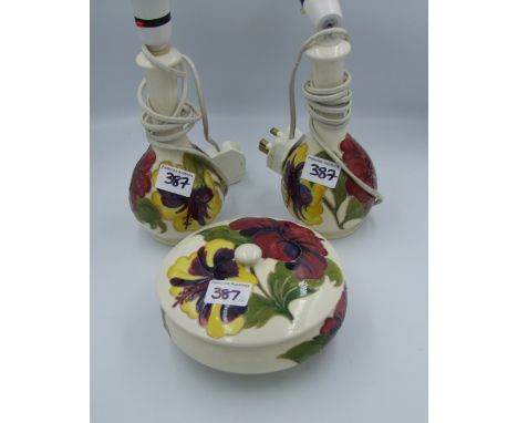 Moorcroft Hibiscus pair of lamp bases together with a lidded pot (chip to lid inner rim). Height of lamps with fittings 22cm 