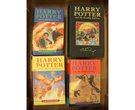 A group of 4 Harry Potter first edition hardback books including a Deluxe edition of Harry Potter and the Deathly Hallows. 