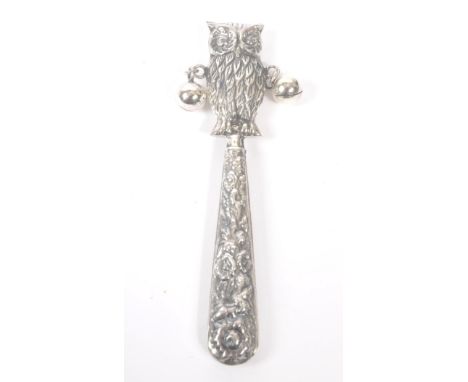 A vintage 20th century silver babies rattle. With owl figure to top, with loose metal balls on tapering repousse handle. 9cm 