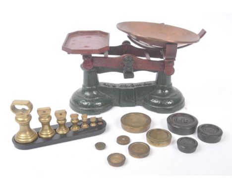 A set of early 20th century cast iron weighing scales. The scales raised on cast metal base with copper weighing basket to on