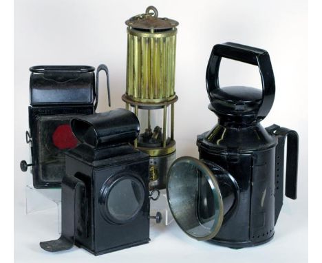 *Four oil-powered lamps. A Premier Lamp and Engineering Co. miner's safety lamp,  having a threaded oil reservoir, hand contr