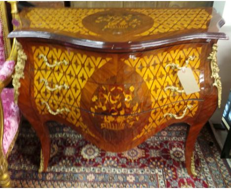An inlaid bombe commode with ormolu mounts and handles