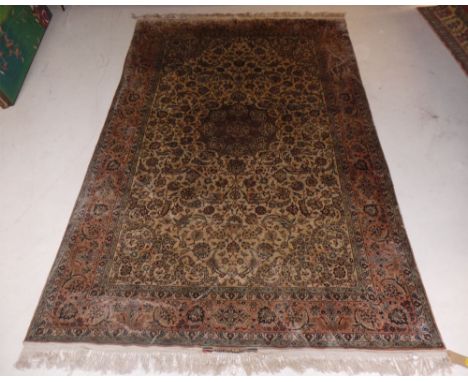 An extremely fine signed Persian silk Tabriz carpet, the central foliate medallion and palmette and vine design on a camel gr