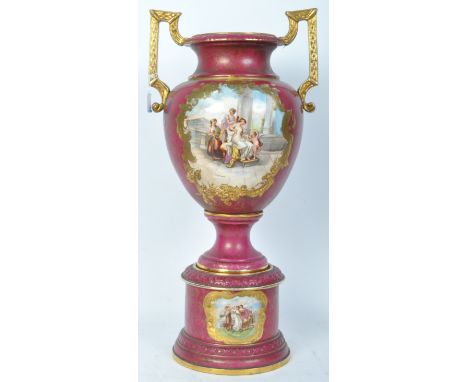 A large 20th century ceramic classical revival urn decorated in a vivid purple colourway. The urn having twin gilt handles, a