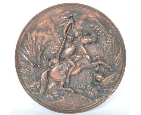 A vintage 20th century copper wall decorative plaque depicting an Amazon like female figure on horse fighting.