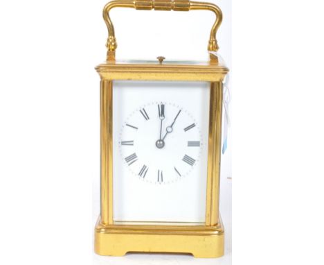 A vintage 20th century brass carriage clock having white face with black roman numeral to the chapter ring and bevelled glass