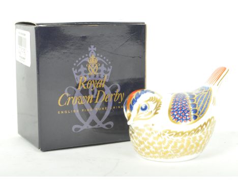 A Royal Crown Derby ceramic paperweight p/w Goldcrest having polychrome decoration with gold stopper to the underside. Marked