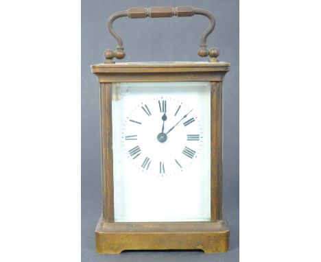 An early 20th century brass cased carriage clock having white face with enamelled black roman numeral to the chapter ring upo