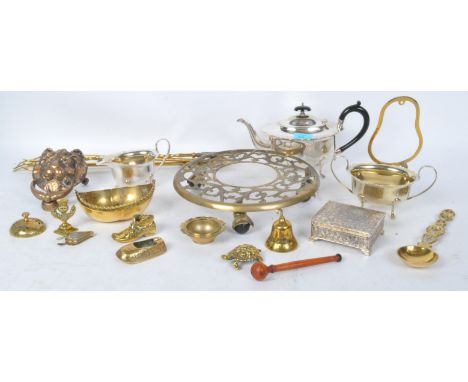 A collection of vintage brass items to include a pierced trivet on castors, a lion head door knocker, a desk bell, a loving s