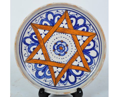 An early 20th century Italian faience tin-glazed plate being hand painted pentagram with rose to centre. Hand painted Faience