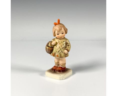 A small hand crafted porcelain figure of a sweet young girl wearing a green dress and holding a basket. M.I. Hummel Club. Goe
