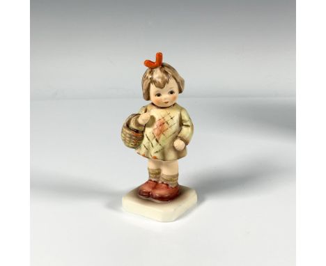 A small hand crafted porcelain figure of a sweet young girl wearing a green dress and holding a basket. M.I. Hummel Club. Goe
