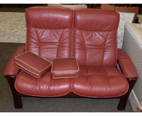 An Ekornes stressless two-seater sofa, modern, the stained beech frame and reclining seats with padded arm rests covered in r