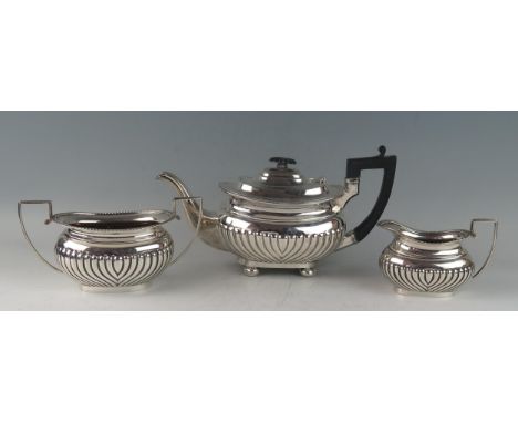 A matched three-piece silver tea service, of barge-shaped outline, the teapot  maker GAG, Sheffield, 1899, the cream jug and 