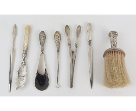 A silver handled brush, silver handled shoe horn, glove stretchers, butter knife, letter openers and button hook. 