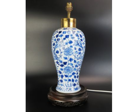 An antique Chinese blue and white vase of 40cm. ovoid form decorated with dragons among flowering shrubs, bears four characte