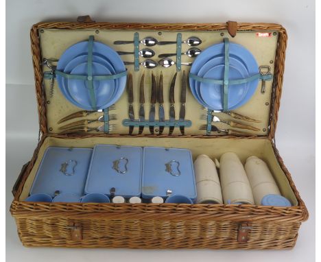 A Coracle wicker picnic hamper possibly for Harrods (label missing), with plates, flatwares, thermos flasks, bottles, cups, s