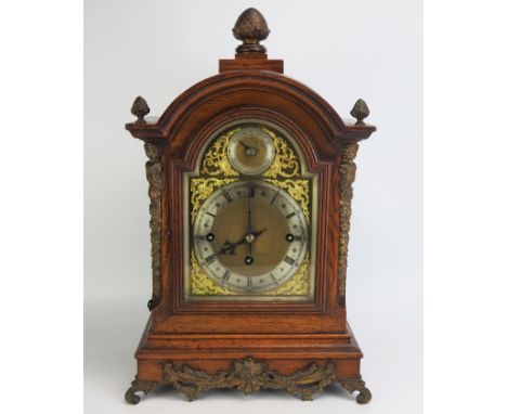 A late Victorian/Edwardian oak mantel clock, of arched outline, with brass arched dial, silvered chapter ring and Roman numer