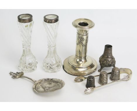 A mixed collection of silverwares, various makers and dates includes candlestick, thimbles, sugar tongs etc. 