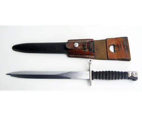 A Swiss Army bayonet, with 24cm double-edged blade, ribbed grip contained in a metal sheath with leather frog. 