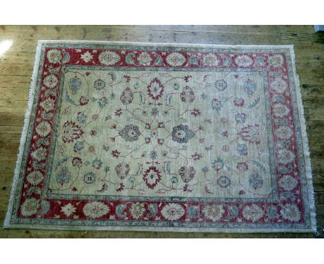 An Afghan Zeigler type rug, the main beige field, with central floral medallion, within trailing foliage, enclosed by a main 